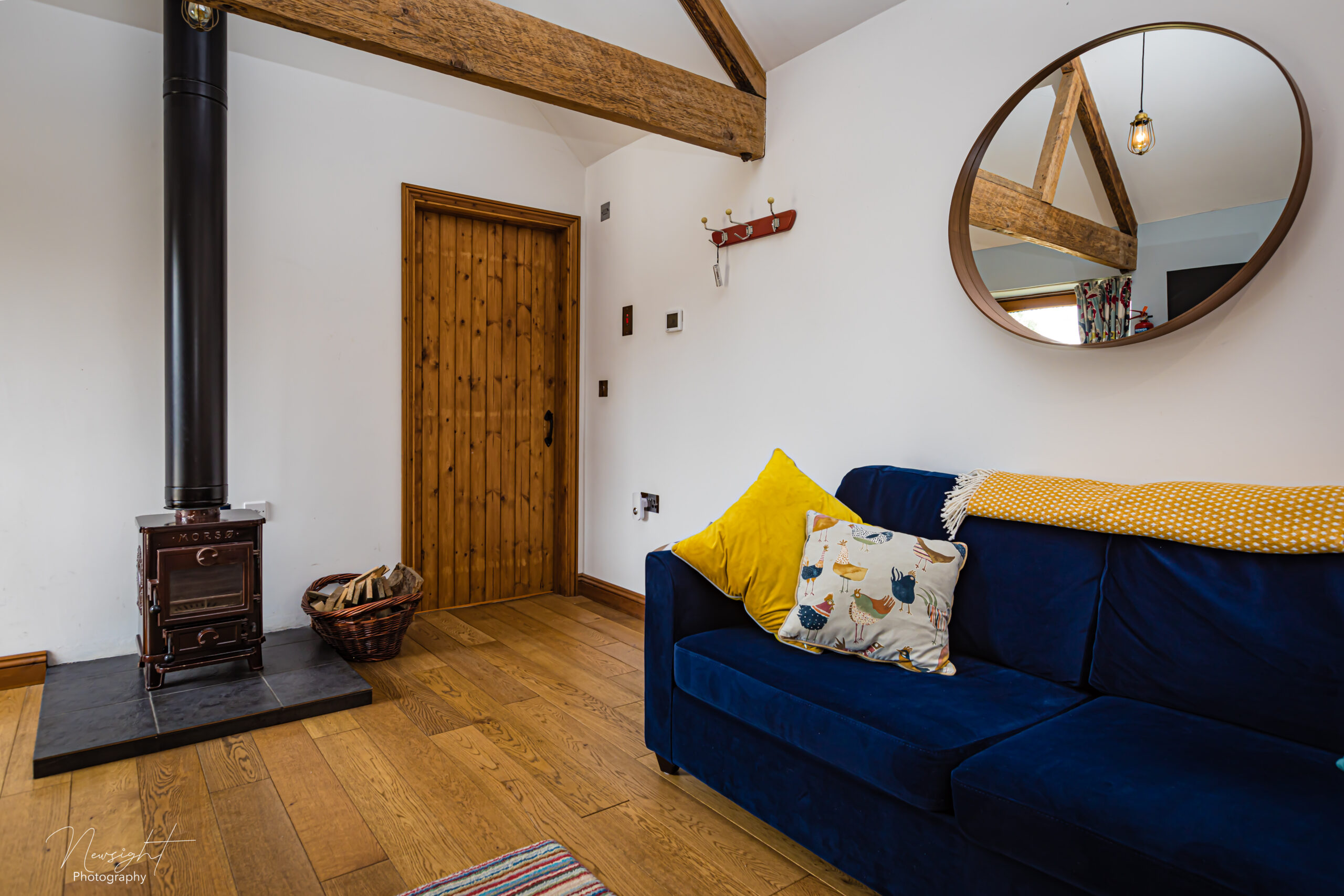 Hay Barn living room with sofa, wood burner and oak beams, Winterton-on-Sea