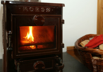Wood burner with log basket in the Hay Barn, Winterton-on-Sea